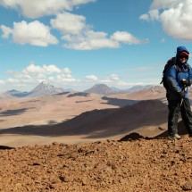 Marion on top of Cerro Incahuasi with Volcanoes Pili and Aguas Caliente in the background